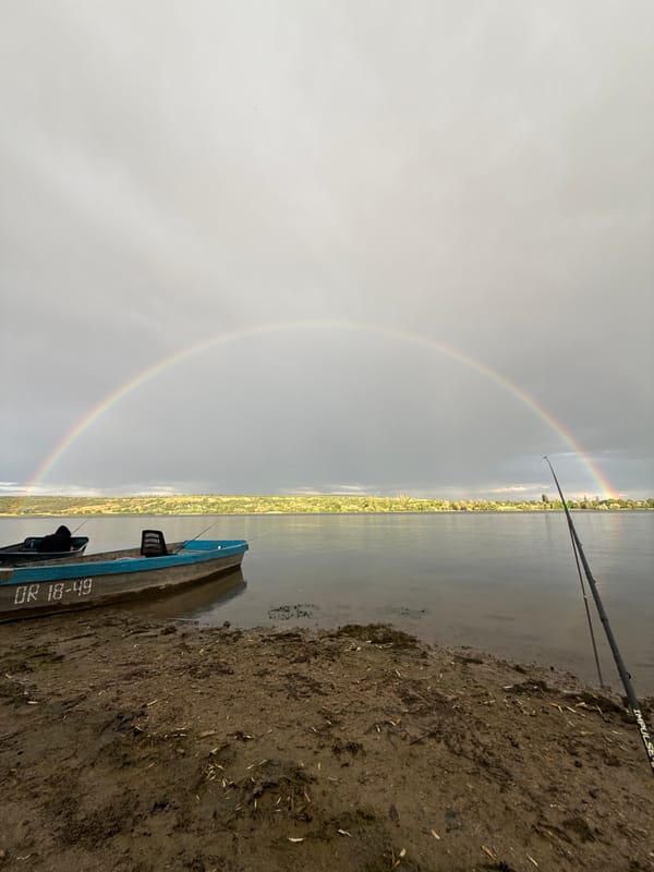 Rainbow arcing over a body of water on an overcast day