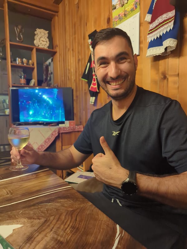Man gives thumbs-up with wine glass in Septemvri home