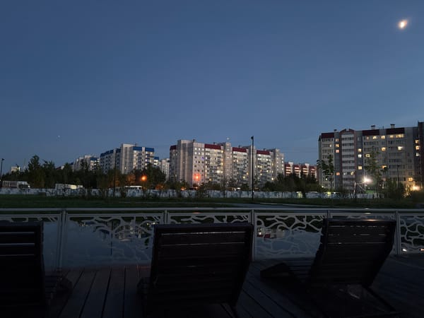 Urban apartment buildings illuminated at dusk captured by witness