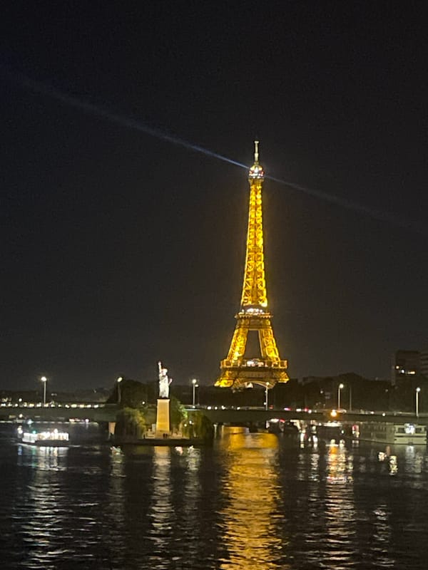Eiffel Tower glowing gold over the Seine at night