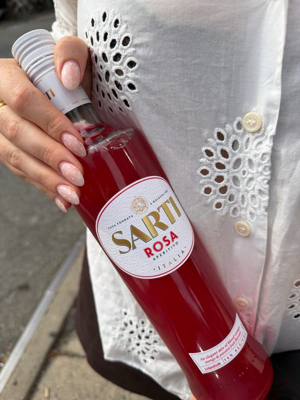 Sarti Rosa Aperitivo bottle held for a closer look