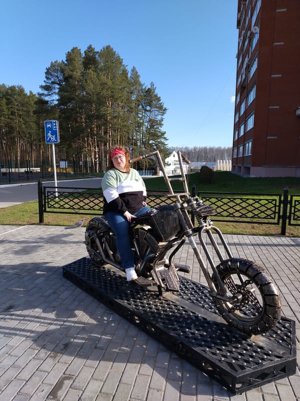 Woman poses on motorcycle sculpture in Chaikovsky, Russia