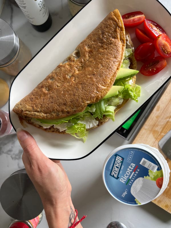 Person prepares breakfast plates with eggs, rice, crepes