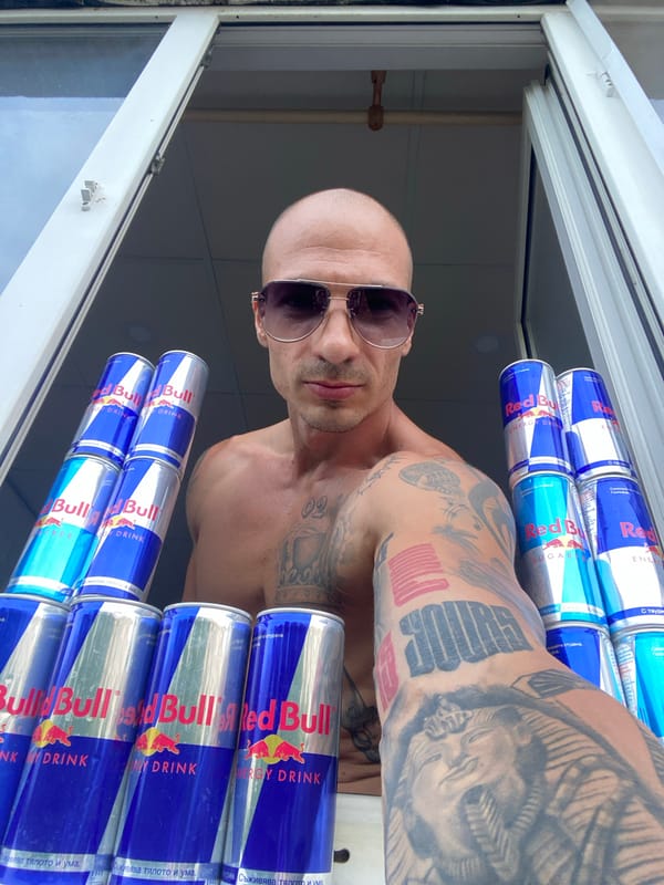 Tattooed man holds Red Bull cans in Pleven