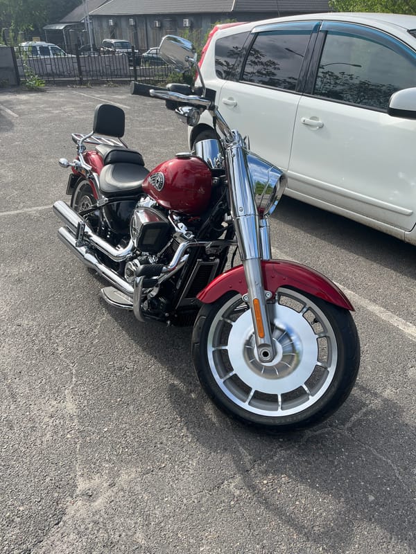 Red motorcycle parked among cars in Kryvyi Rih
