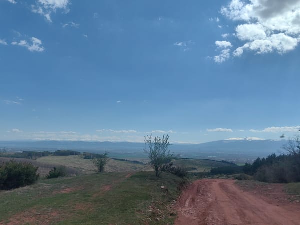 Vehicle travels red dirt road through rural Lokorsko countryside