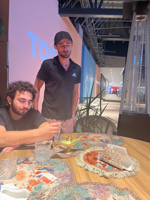 Two men sit at table in Mexican public space