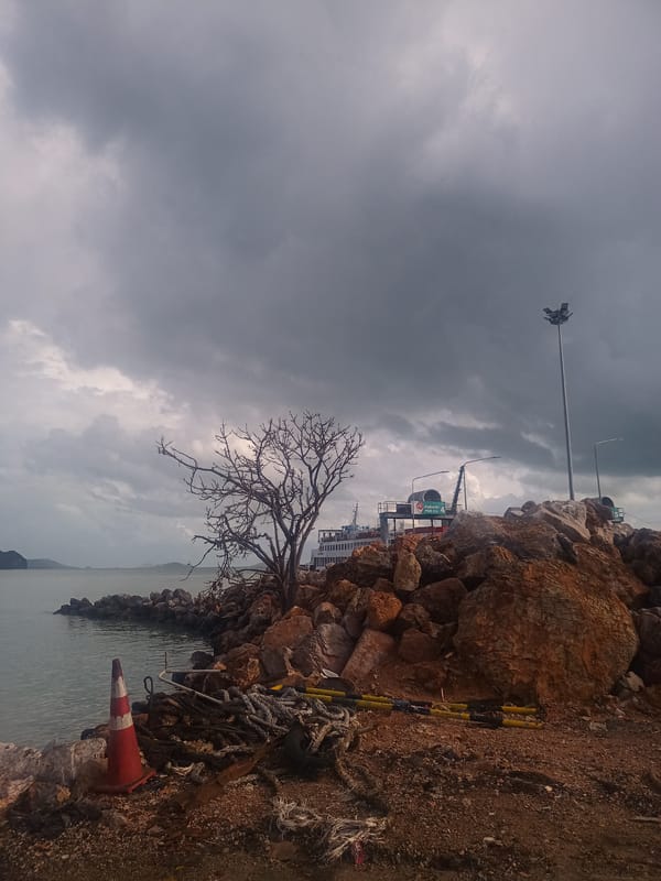 Ferry operations documented at Thai coastal harbor under overcast skies