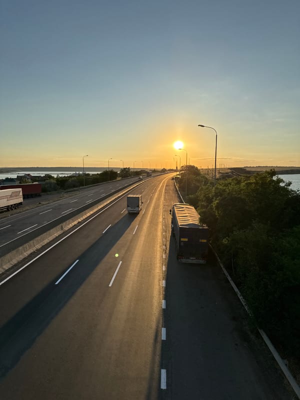 Sunset highway traffic along a Ukrainian waterfront, summer solstice