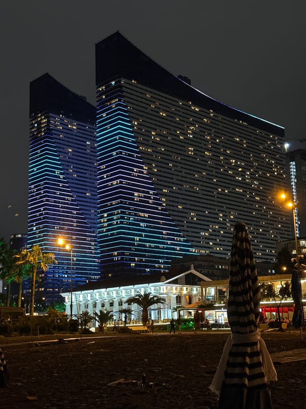 Batumi's angular towers glow blue and white after dark