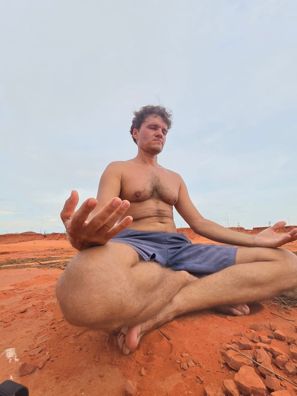 Man poses on red sand formations in Mui Ne