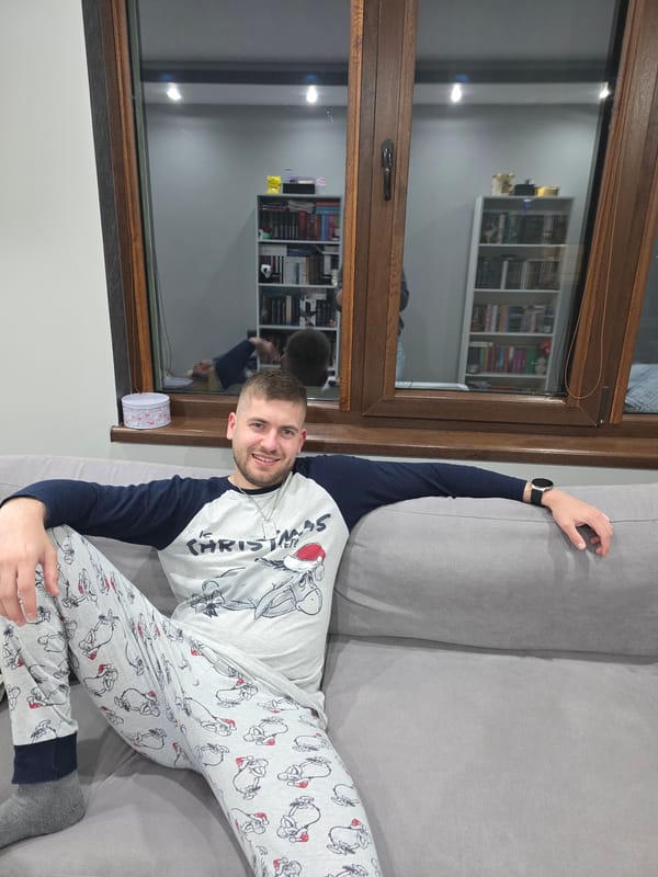 Man in Christmas pajamas holds pineapple at Bulgarian home