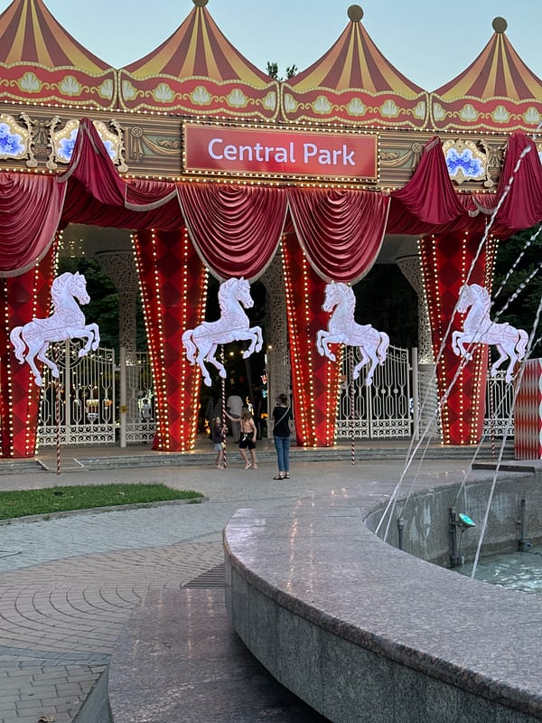Evening at Tashkent's Central Park — lights, fountains, and a carousel.