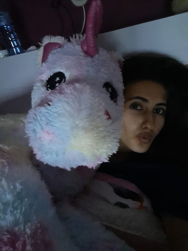 Person shares quiet evening with unicorn plush, candles