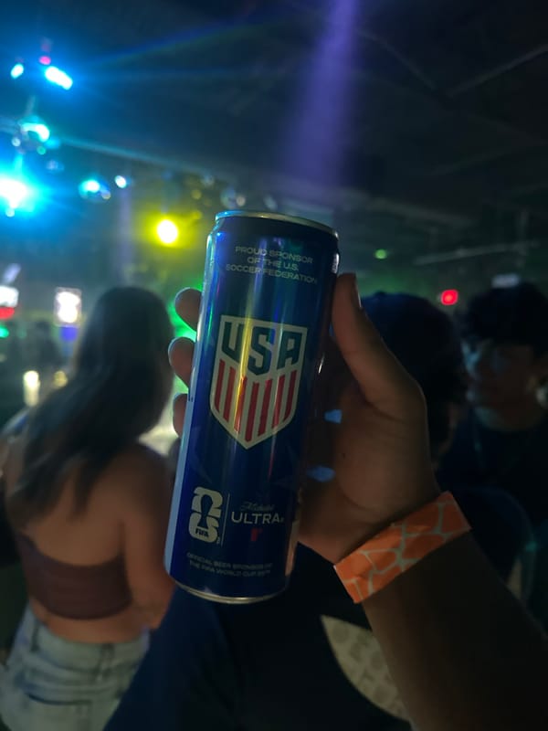 Person holds USA-branded blue can at Tampa indoor event