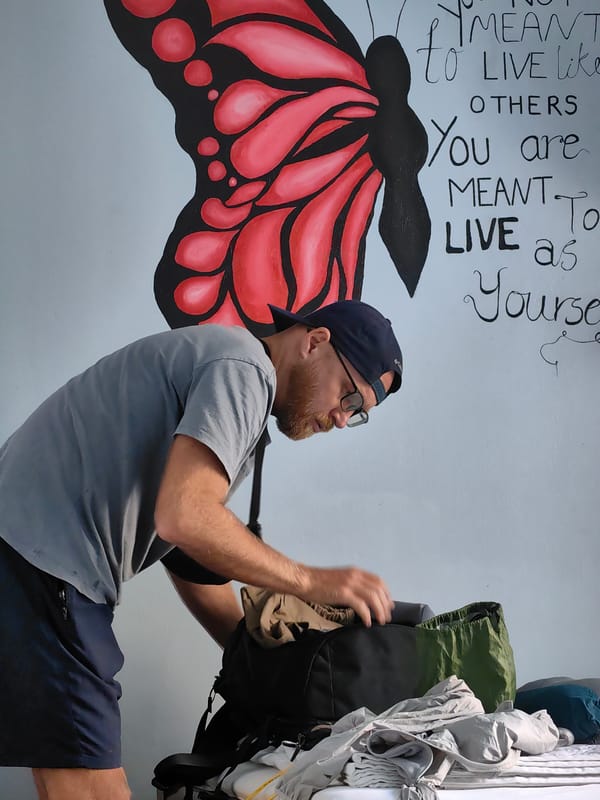 Woman applies mascara during morning routine in Vietnamese bedroom