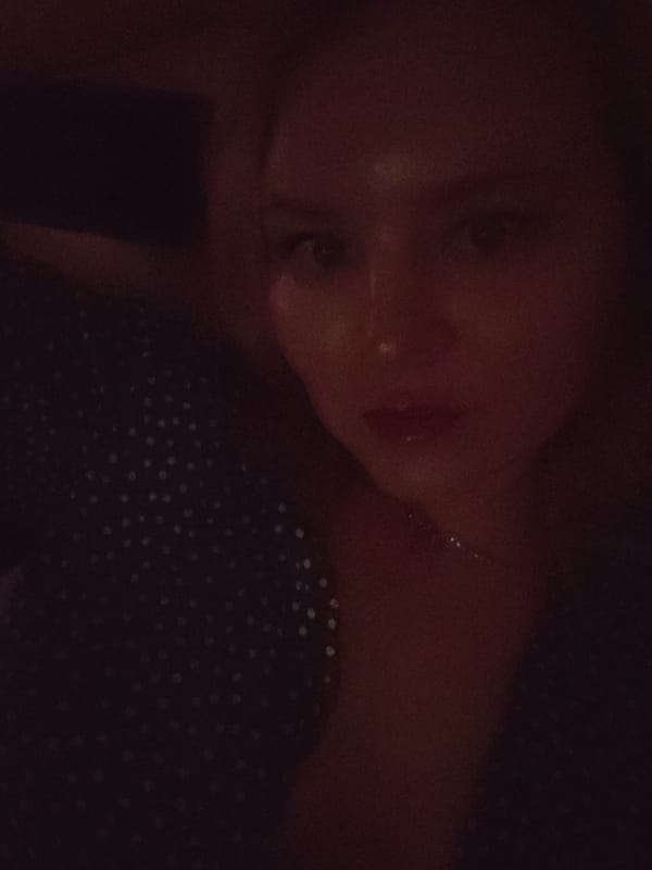 Woman enjoys private movie night with wine in Izhevsk bedroom