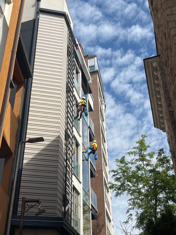 Window washers clean modern building in Budva Montenegro