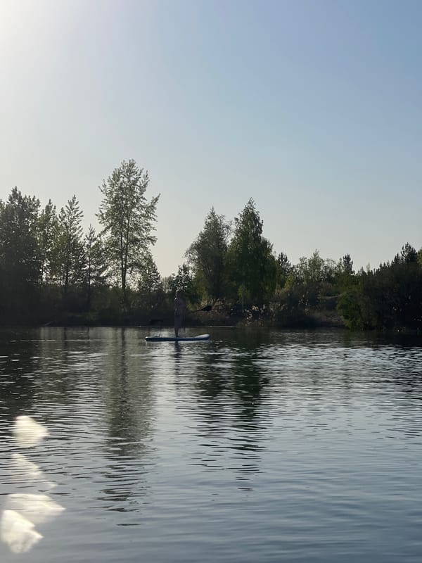 Paddleboarder enjoys sunny afternoon on lake near Novyi, Russia