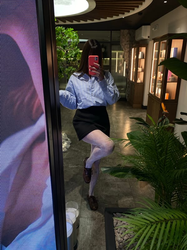 Woman takes selfies with pink phone in Votkinsk mirror