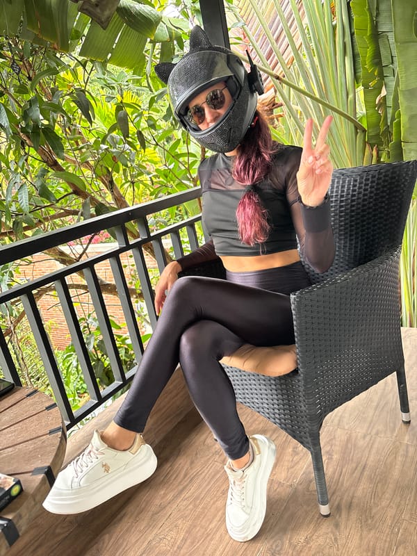 Cat-ear helmet and all-black fit in a tropical outdoor setting