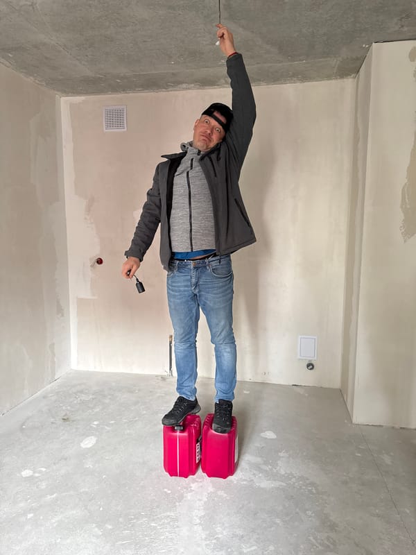 Man installs lighting fixture in unfinished room in Izhevsk