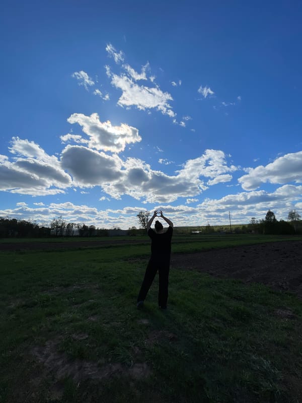 Person makes heart gestures in Russian countryside fields