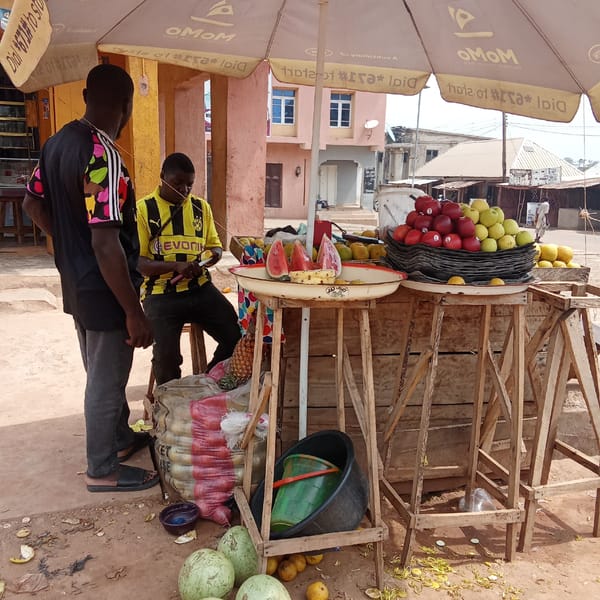 Fruit vendor serves customers at roadside stall in Akwanga