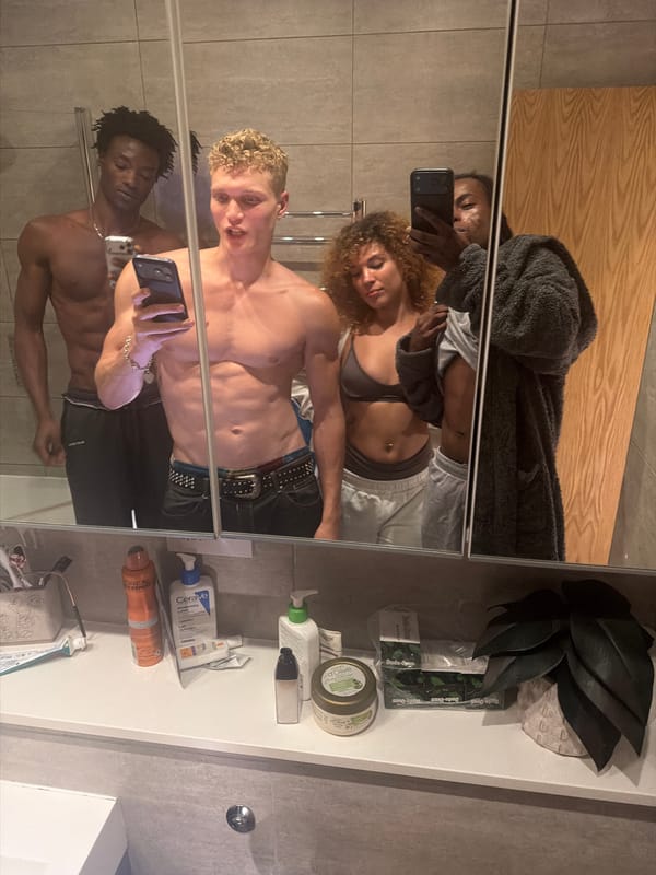 Young adults take group mirror selfies in London bathroom