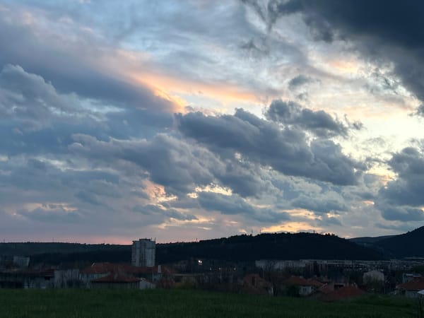 Storm clouds gather over city with golden-domed church