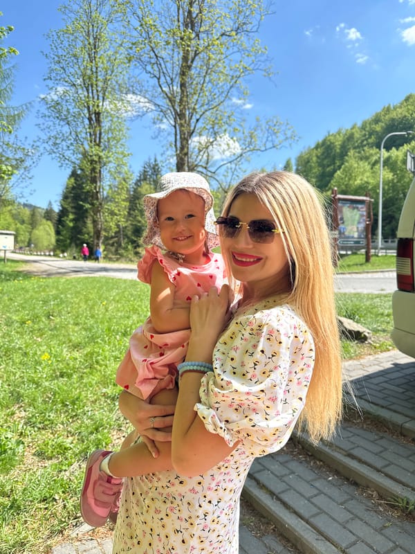 Woman with baby uses public fountain in Wisła