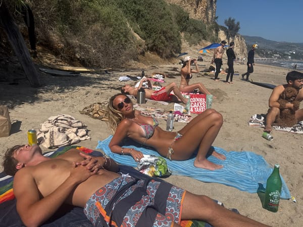 Beachgoers relax on Malibu sand during March evening