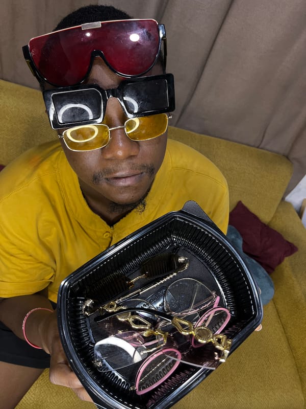 Sunglasses vendor displays eyewear collection on couch in Accra