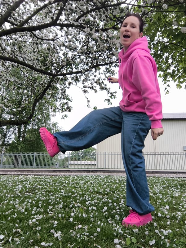 Woman in pink stands among flower petals in Riga