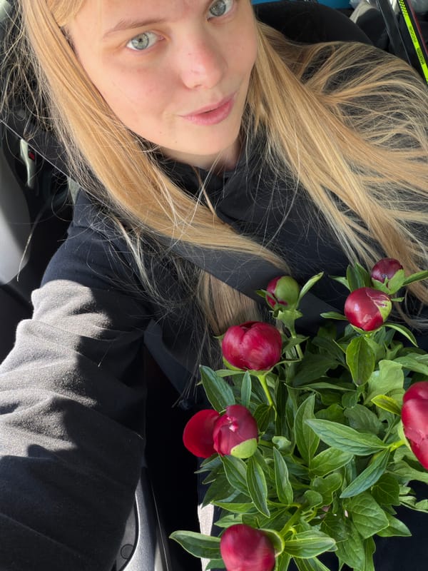 Woman with peonies stops at gas station in Chaikovsky