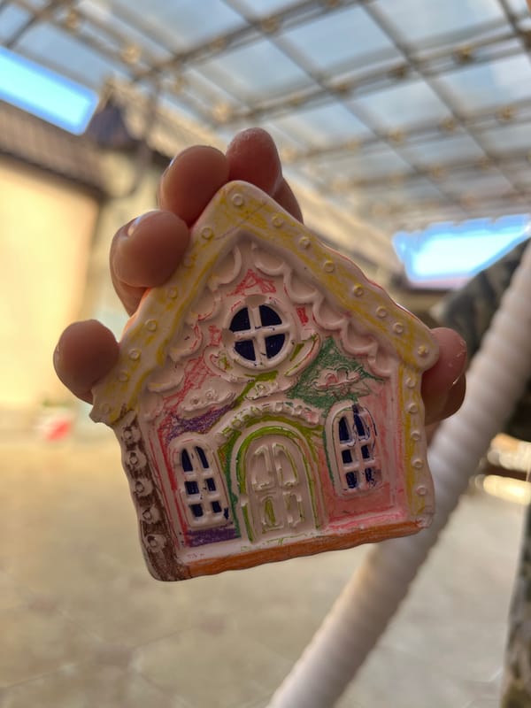 Boy displays painted clay house ornaments in Kaspiysk