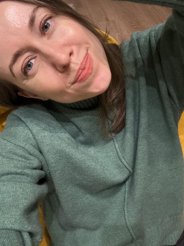 Woman in green sweater photographed on yellow surface in Kudrovo