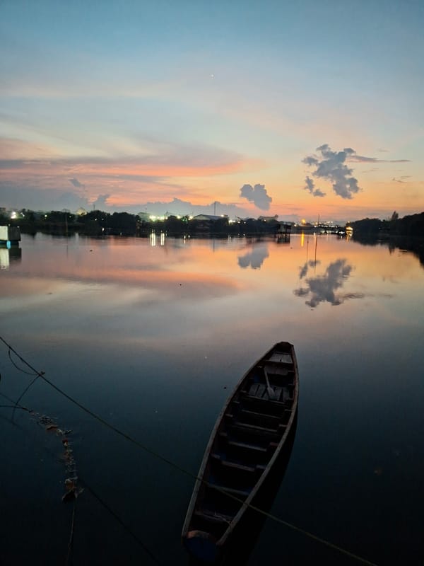 Peaceful dawn waterscape with wooden boat captured in Lhokseumawe