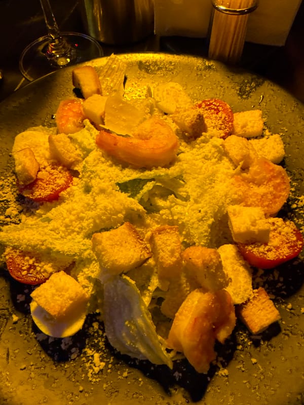 Woman enjoys wine and Caesar salad at restaurant