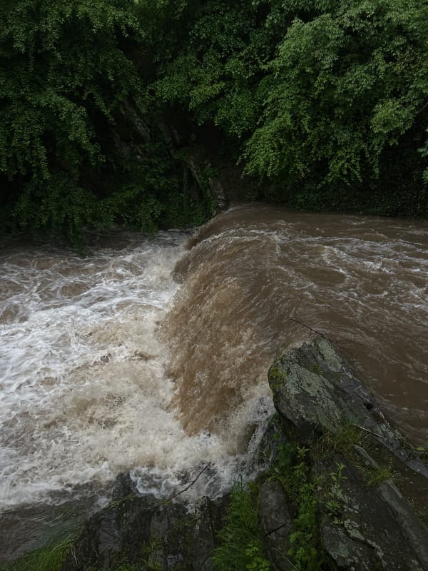 Storm-swollen waterways and flooding documented across unknown location