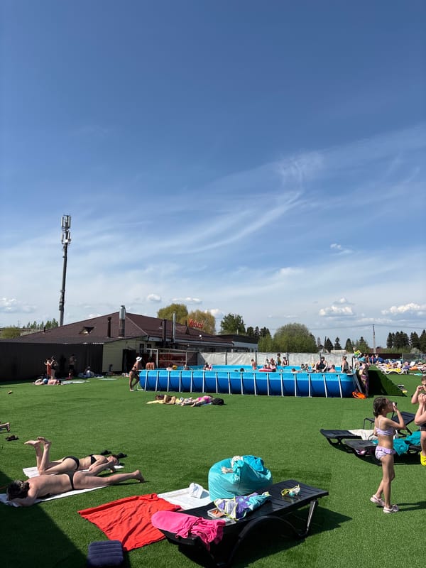Swimmers and sunbathers enjoy outdoor pool in Гамово, Russia