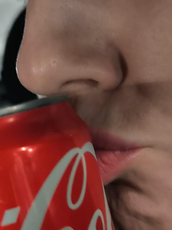 Person drinks Coca-Cola in Riga, Latvia