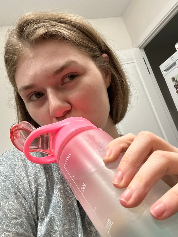 Person drinks from pink water bottle in Kazan