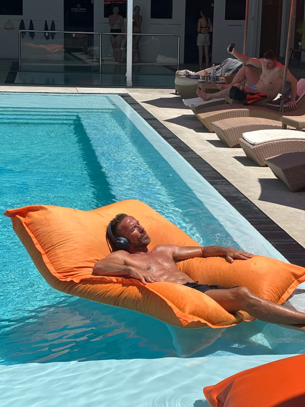 Headphones on, floating in a Ko Samui pool