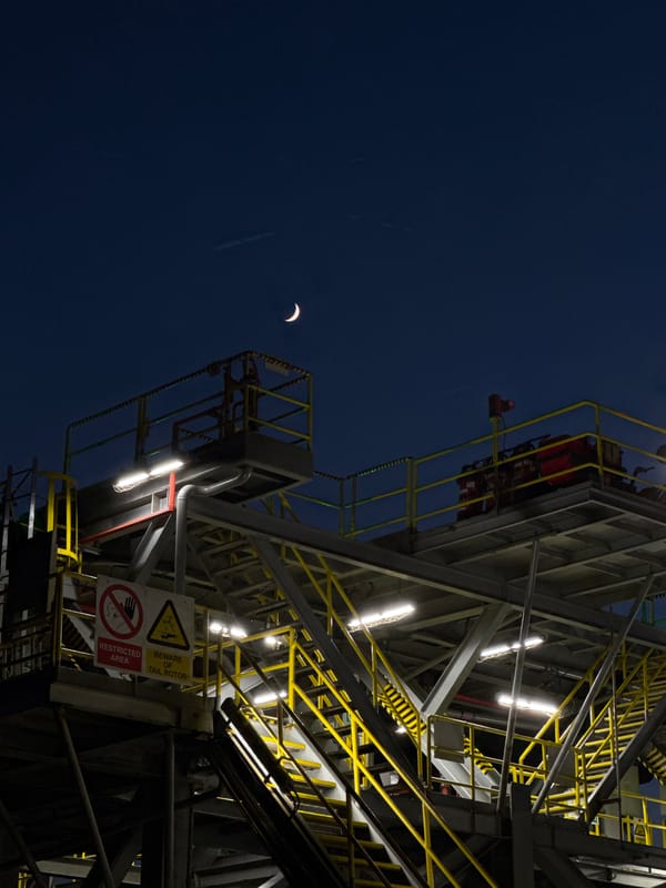Adriatic offshore rig at dusk, crescent moon rising