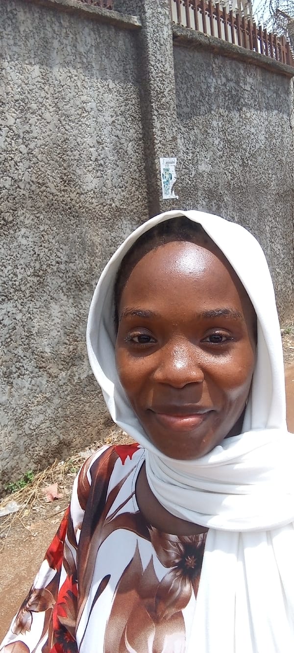 Woman in headscarf walks through Abuja neighborhood
