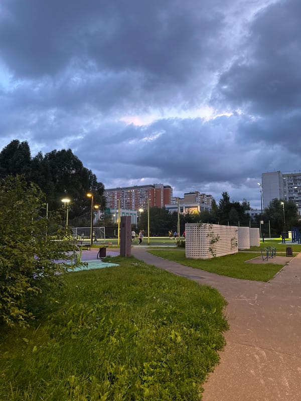 Dusk settles over a Moscow residential neighborhood with pickup soccer