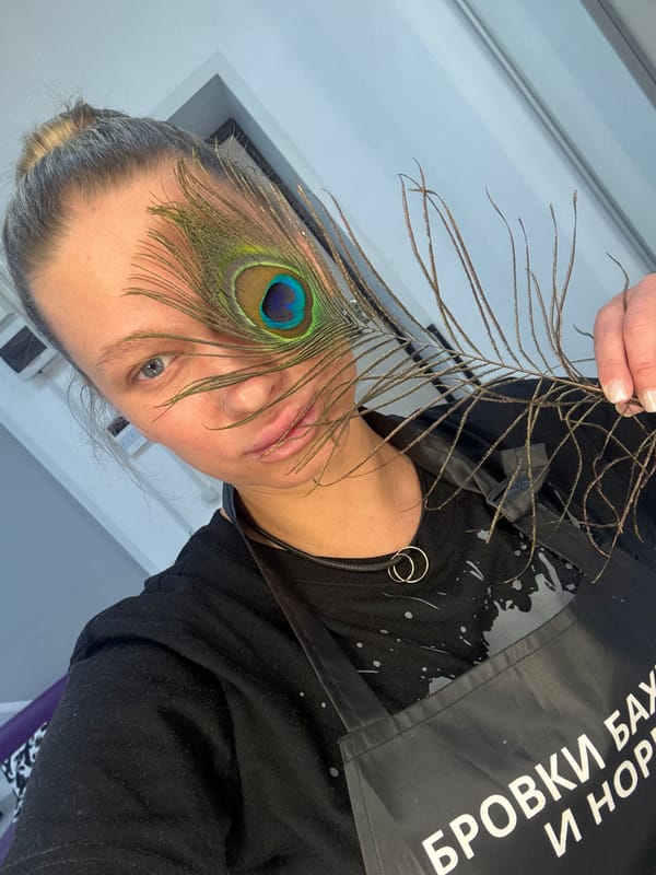 Person holds peacock feather over eye in Perm, Russia