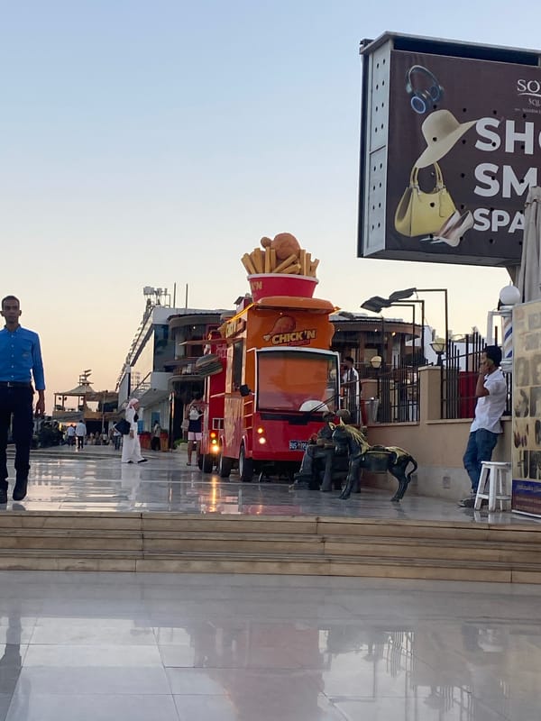 Sharm El Sheikh promenade at dusk, sculptures and market stalls