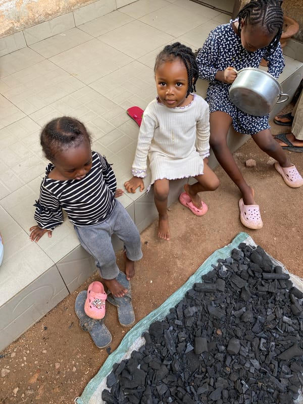 Three girls sit together in Bukuru, Nigeria
